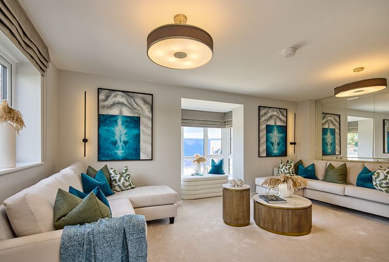 A living room with a sectional sofa, accent pillows, and abstract artwork.