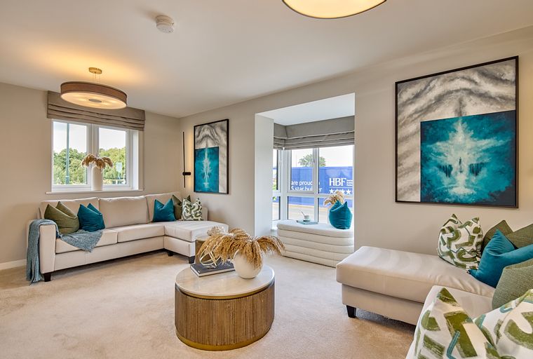 A living room with a sectional sofa, coffee table, and artwork.
