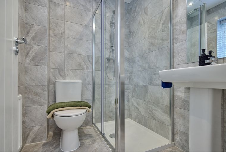 A bathroom with a toilet, a shower stall, and a sink.