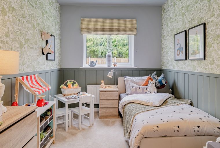 A child's bedroom with a bed, a small table and chairs, and themed decor.