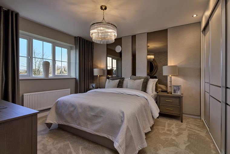 A bedroom with a bed, bedside tables, a window, and a wardrobe.