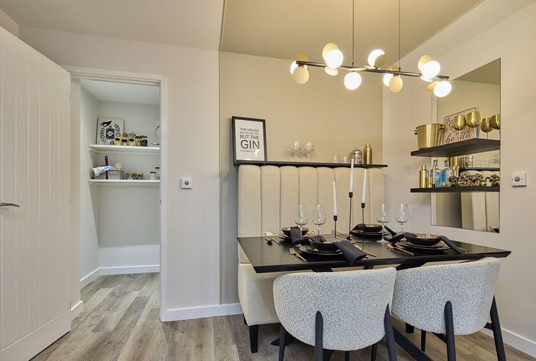 A dining table with banquette seating and chairs, set for a meal.