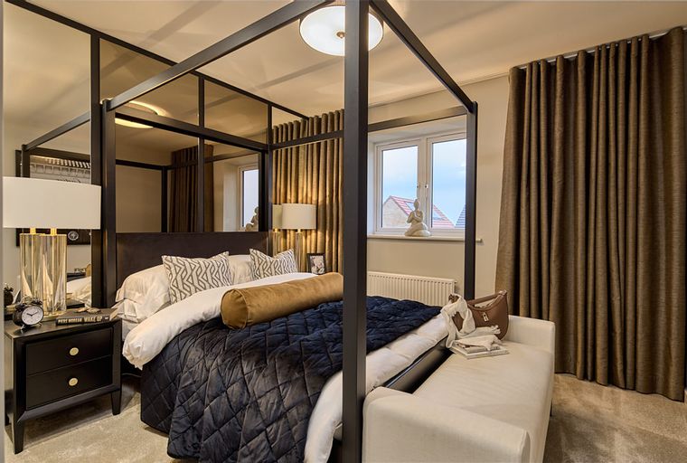 A bedroom with a four-poster bed, bedside tables, and curtains.