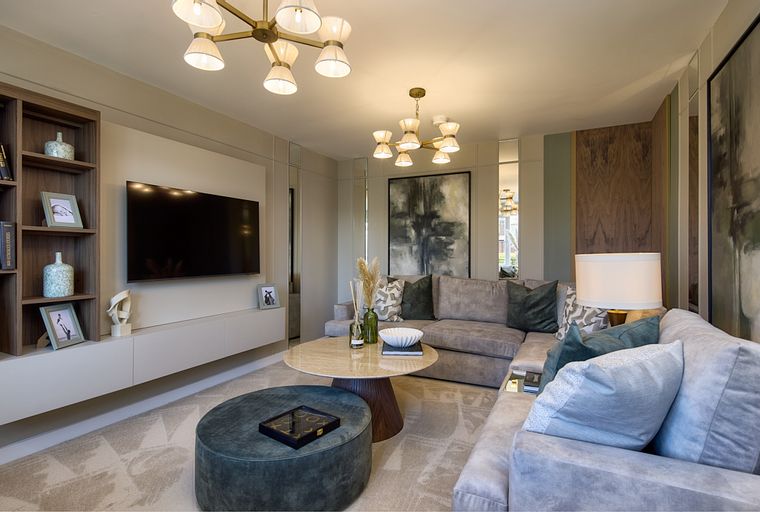 A living room with a sectional sofa, coffee table, ottoman, and a television.