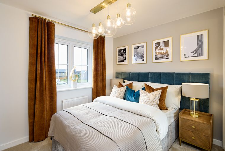A bedroom with a bed, headboard, curtains, and a bedside table.