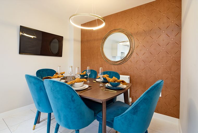 A dining room with a table, chairs, and a mirror.