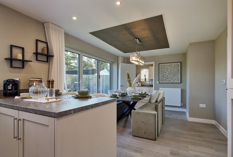 A kitchen and dining area with a kitchen island, dining table, and bench seating.