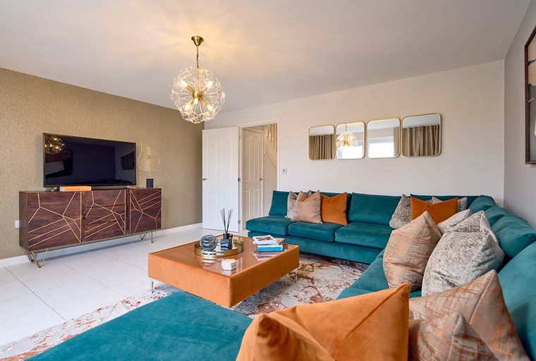 A living room with a teal sectional sofa, a media console with a TV, and a coffee table.