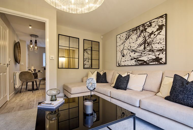 A living room with a sectional sofa, coffee table, and abstract art.