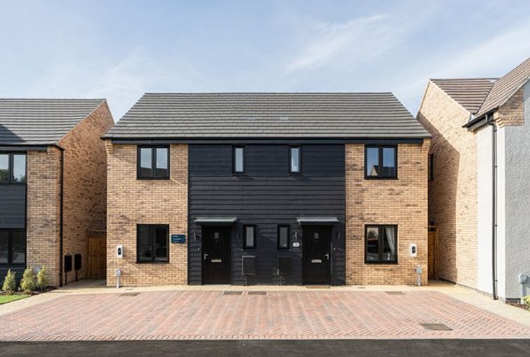 A row of modern semi-detached houses with brick and dark timber facades.