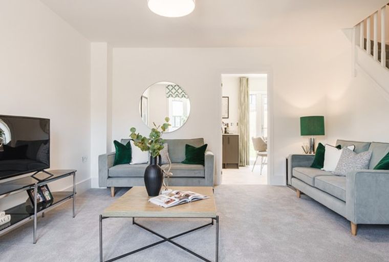A living room with two grey sofas, a coffee table, and a television.