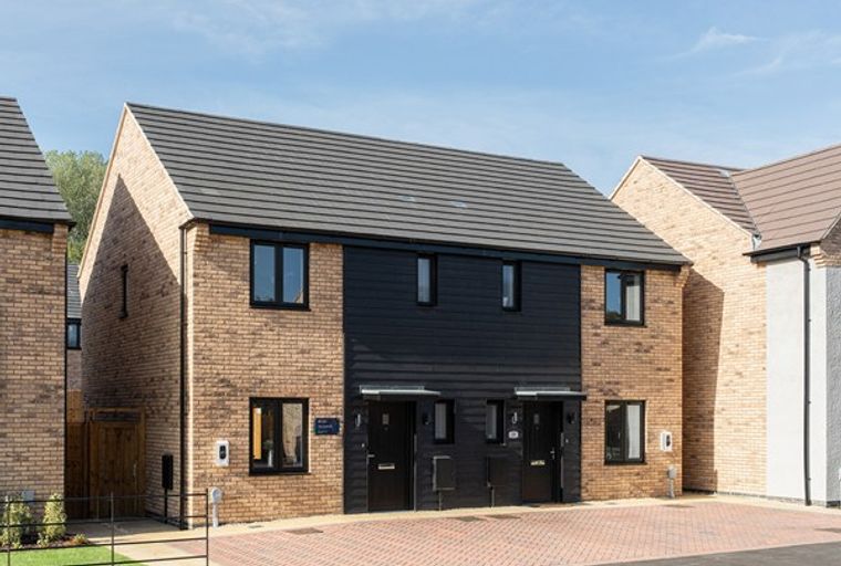 A pair of modern townhouses with light brick and dark timber facades.