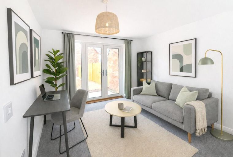 A living room with a sofa, coffee table, desk, and artwork.