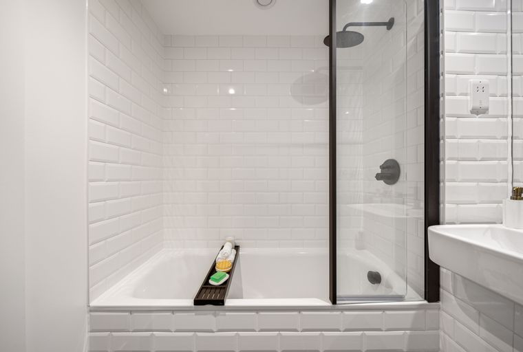 A bathroom with a bathtub, shower, and sink.