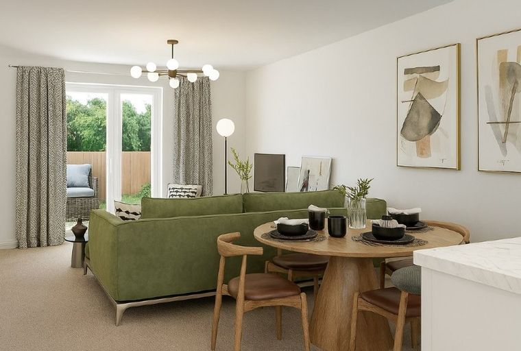 A living and dining area with a green sofa, a round dining table, and abstract art on the wall.