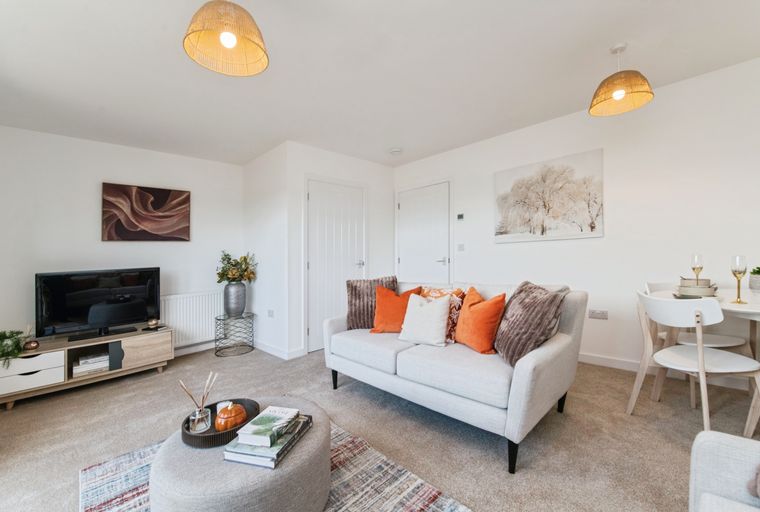 A living room with a sofa, coffee table, and television.
