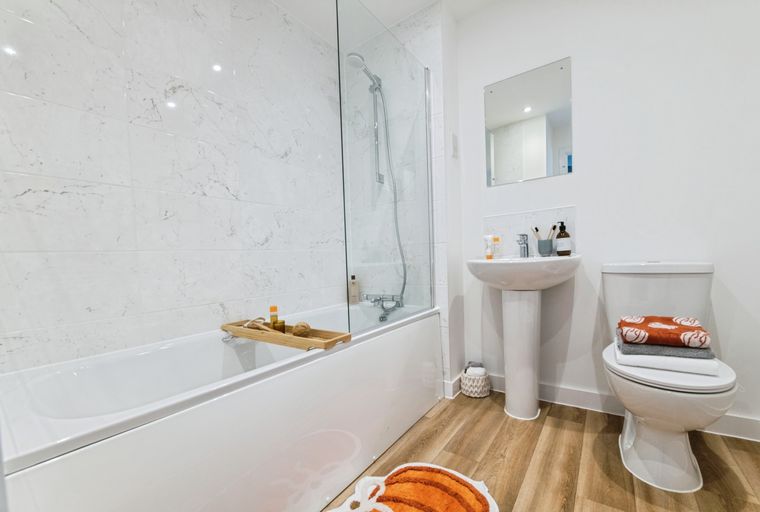 A bathroom with a bathtub, shower, sink, and toilet.