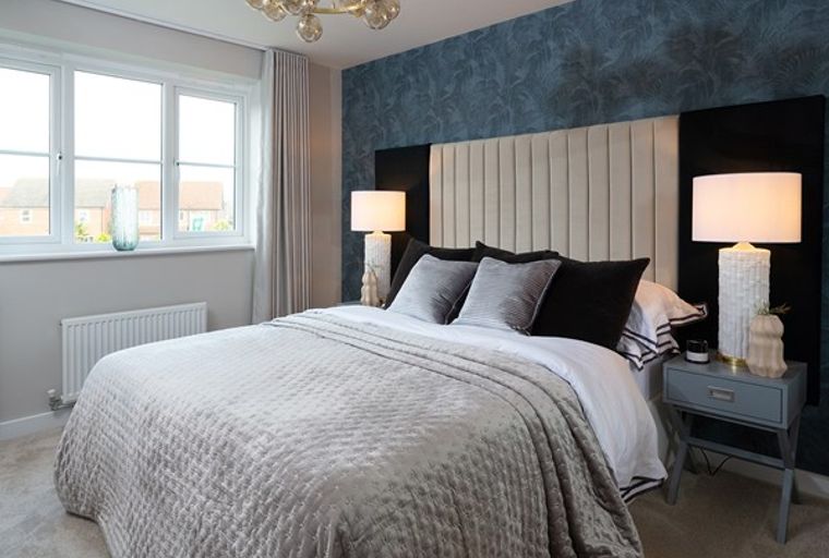 A bedroom with a bed, bedside tables, lamps, and a window.