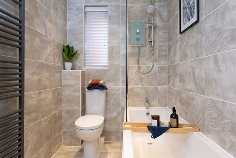 A bathroom with a toilet, bathtub, and shower.