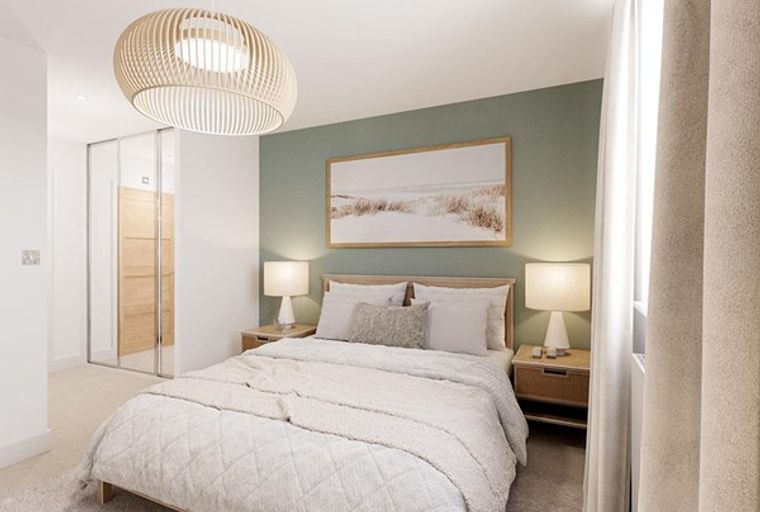 A bedroom with a bed, bedside tables, lamps, and a large framed picture on the wall.
