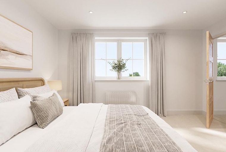 A bedroom with a bed, pillows, a headboard, a window, and a door.