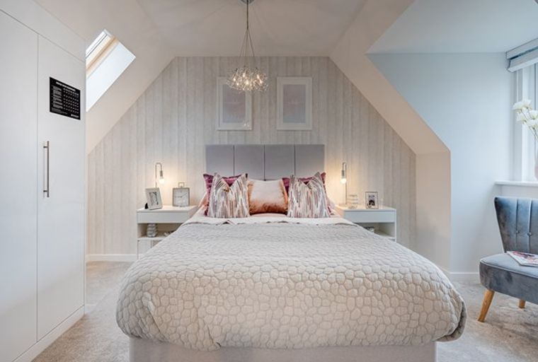 A bedroom with a bed, bedside tables, lamps, and a wardrobe.