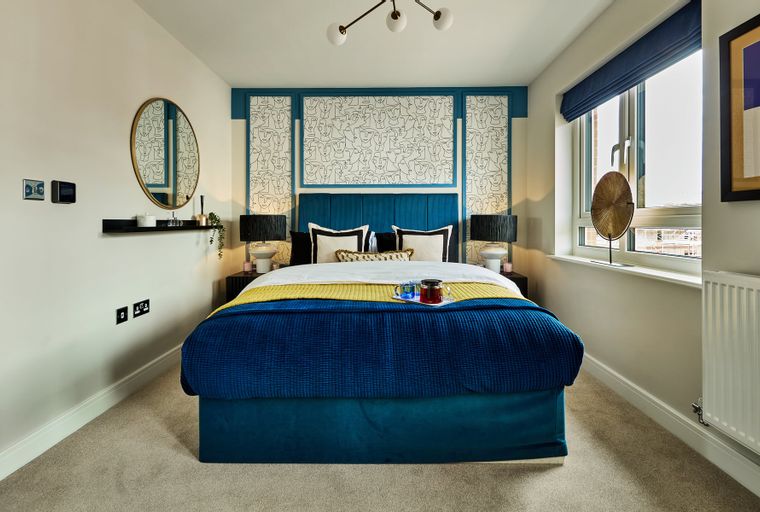 A bedroom with a bed, bedside tables, lamps, and a window.