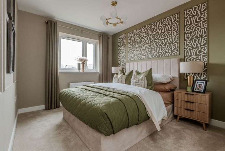 A bedroom with a bed, bedside table, and a window.