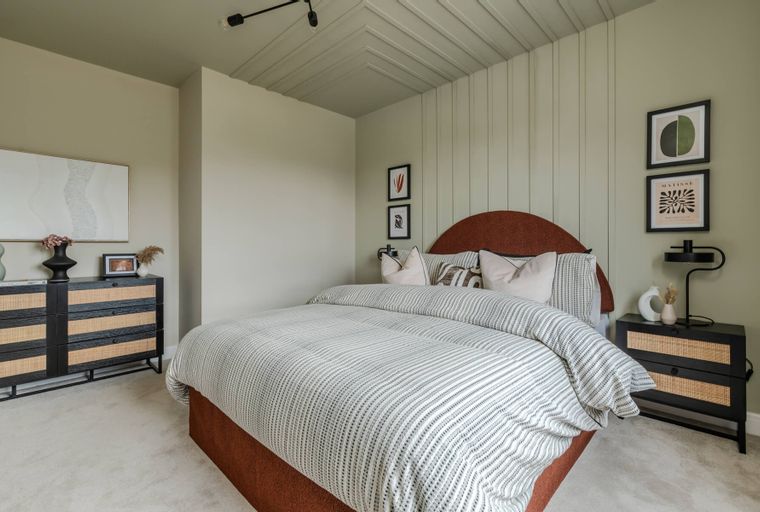 A bedroom with a bed, nightstands, and a dresser.