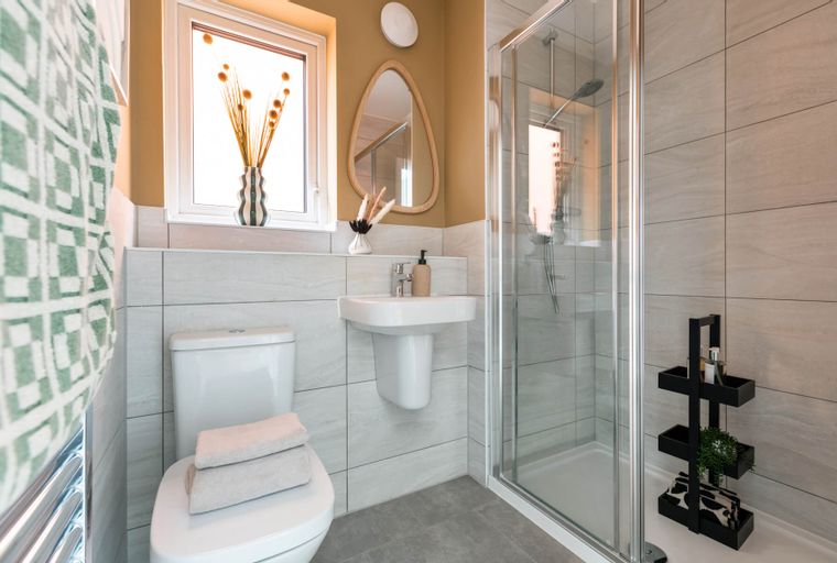 A bathroom with a toilet, sink, and shower.