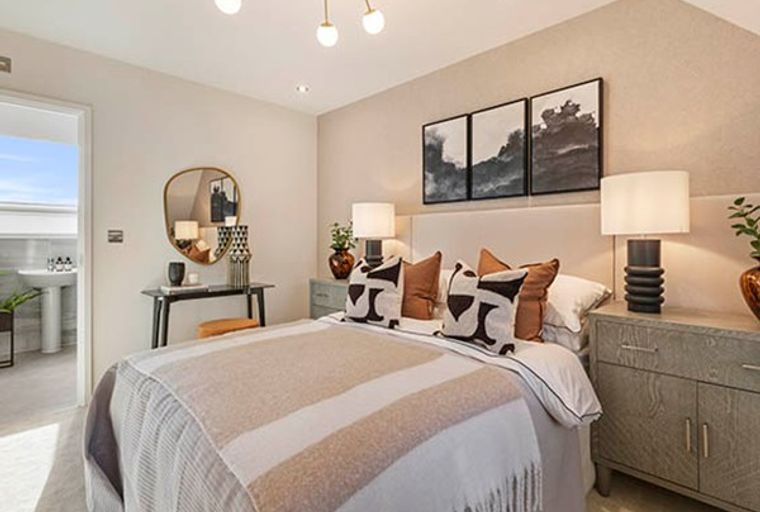 A bedroom with a bed, nightstands, and artwork.
