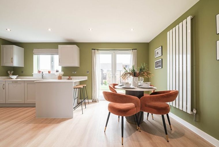 A kitchen and dining area with cabinets, an island, a table, and chairs.