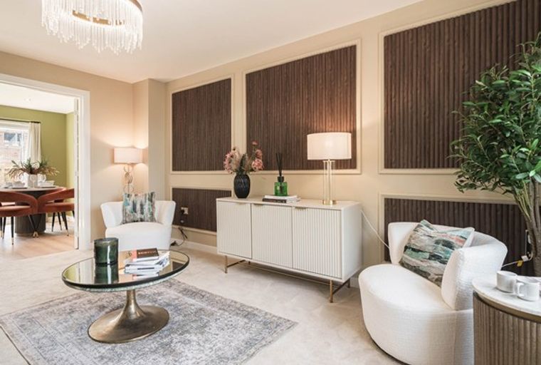 A living room with a chandelier, two armchairs, a coffee table, and a sideboard.