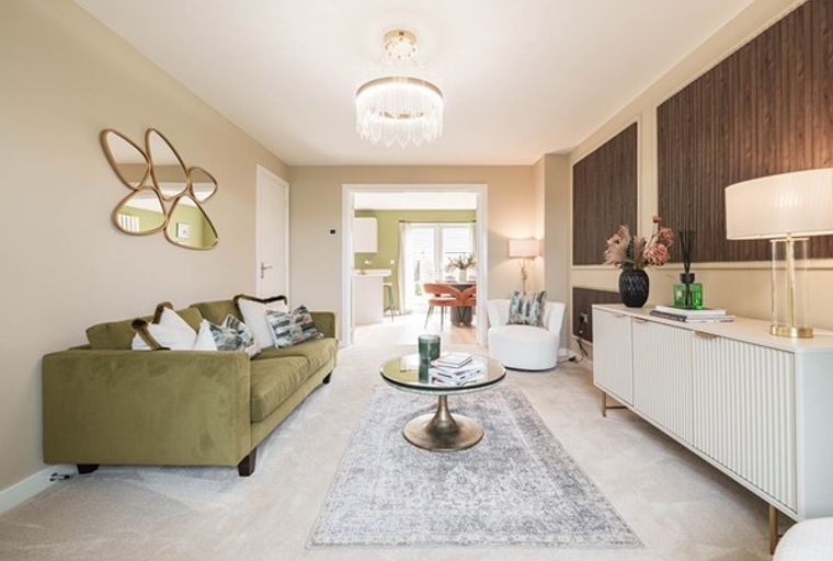 A living room with a green sofa, coffee table, rug, and sideboard.