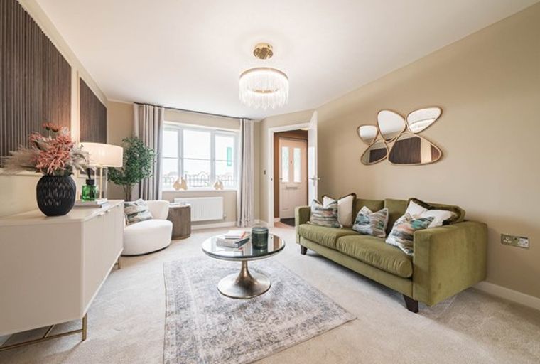 A living room with a green sofa, coffee table, and decorative mirrors.