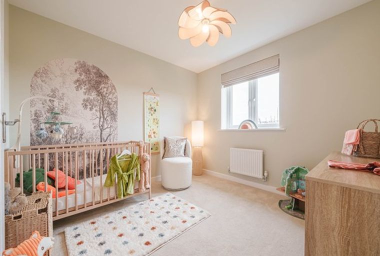 A nursery with a crib, a dresser, and a window.