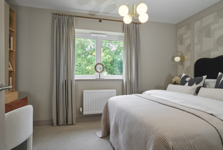 A bedroom with a bed, window, and curtains.