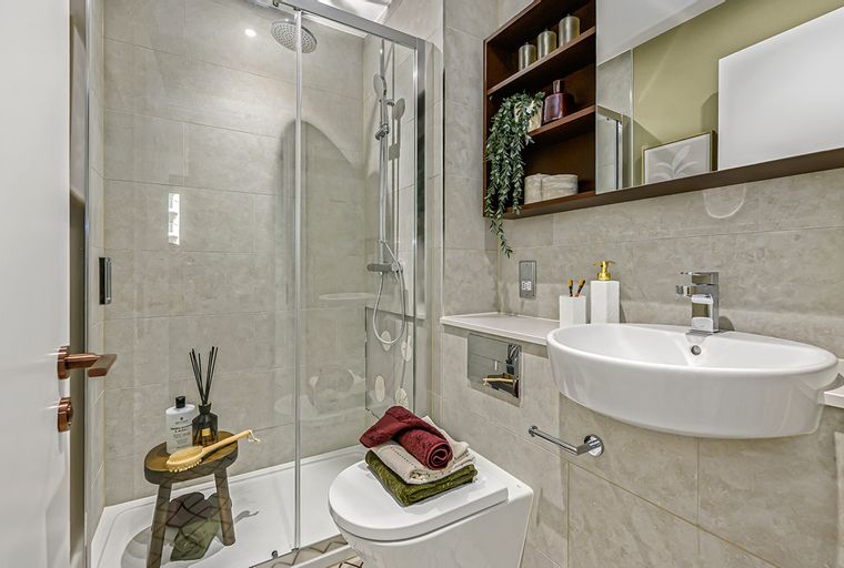 A bathroom with a shower, toilet, and sink.