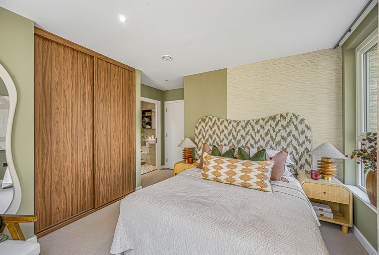 A bedroom with a bed, wardrobe, and bedside tables.