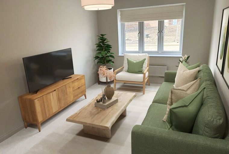 A living room with a sofa, armchair, coffee table, and television.