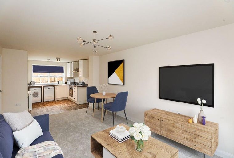 A living room and kitchen area with a sofa, dining table, and kitchen appliances.