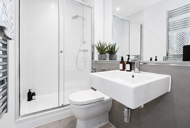 A bathroom with a shower, toilet, and sink.