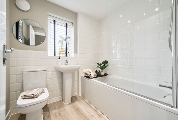 A bathroom with a toilet, sink, and bathtub.