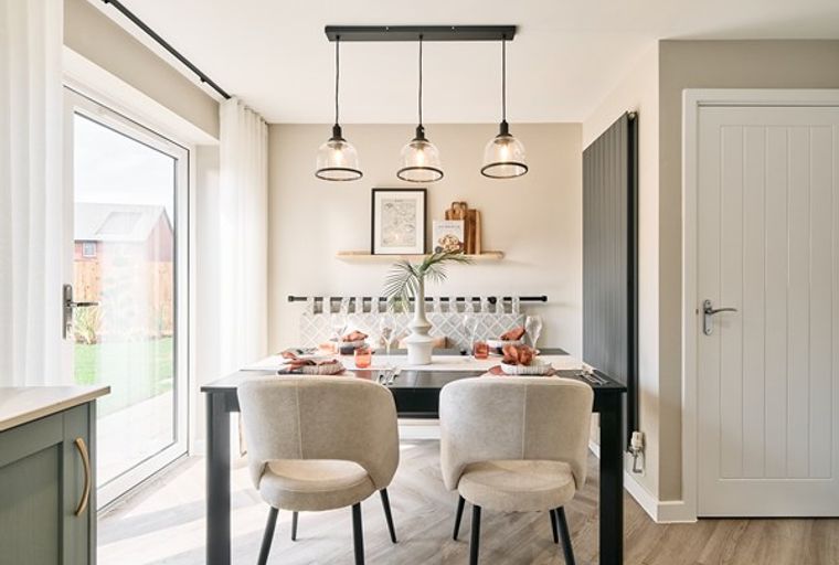 A dining area with a table, chairs, and pendant lights.