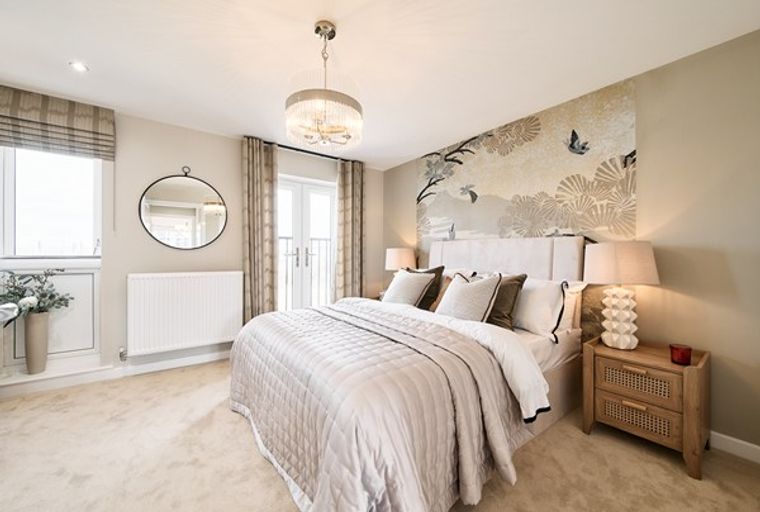 A bedroom with a bed, bedside tables, and a decorative wallpaper.