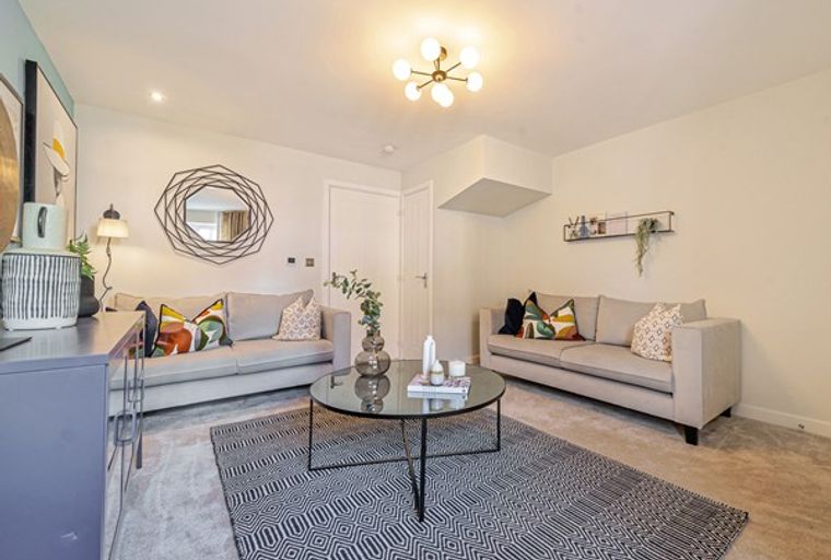 A living room with two sofas, a coffee table, and a rug.