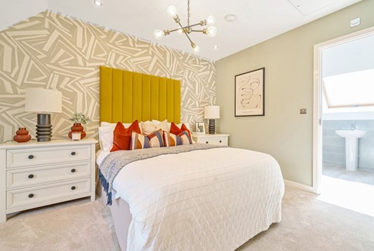A bedroom with a bed, nightstands, and a patterned wallpaper.
