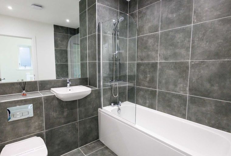 A bathroom with a bathtub, shower, sink, and toilet.