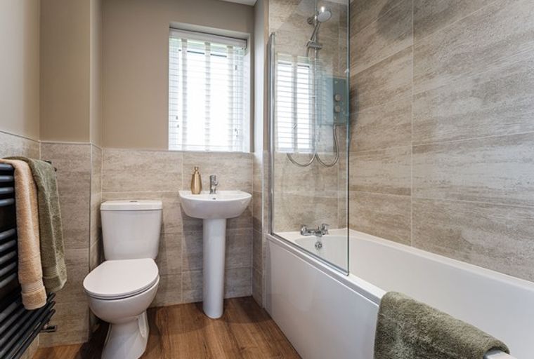 A bathroom with a toilet, sink, bathtub, and shower.