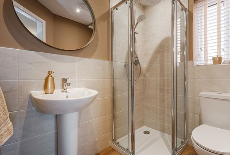 A bathroom with a sink, a shower, and a toilet.